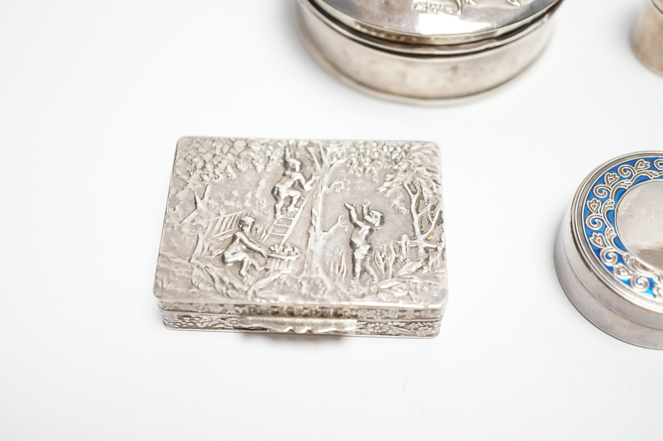 An Edwardian silver circular trinket box, embossed with a rose, Chester, 1909, 65mm, two modern pill boxes, silver and 800 standard with enamel and a modern Italian silver pill box.